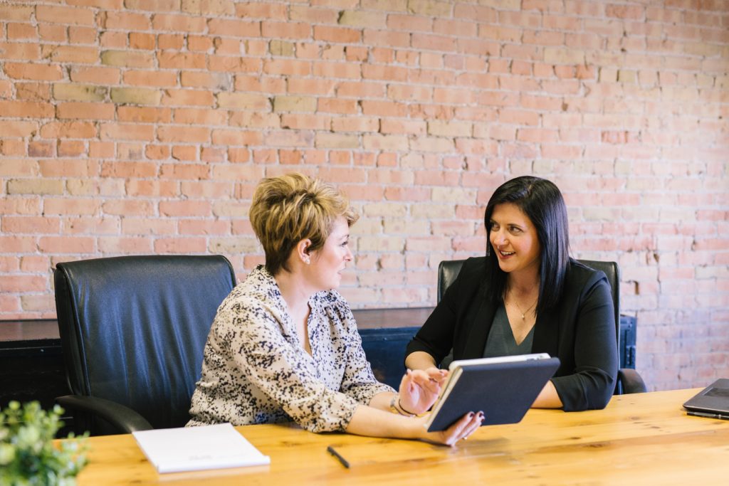 femmes en entreprise avec le sourire qui discutent face à face. Bien-être au travail.